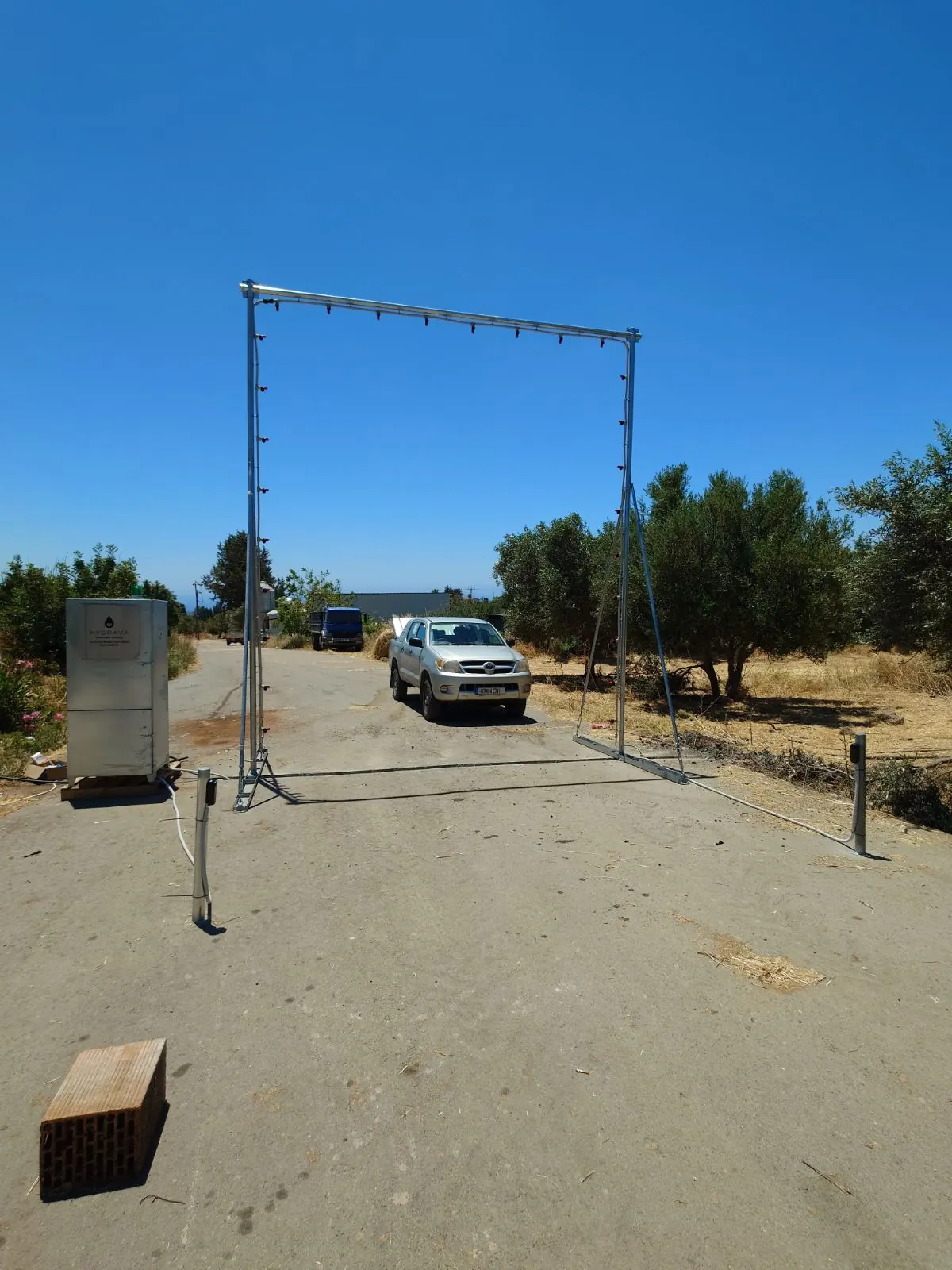 Αγροτικό pickup περνά μέσα από υγειονομική πύλη απολύμανσης Hydrava σε είσοδο εκτροφής